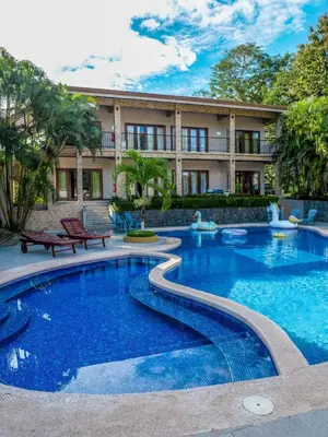 a swimming pool in front of a building at Hotel Amira in Carrillo