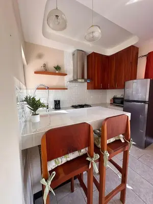 a kitchen with two chairs at a kitchen island at Hotel Amira in Carrillo