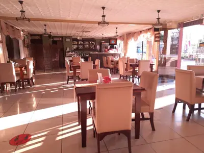 a dining room with wooden tables and chairs at Hotel y Restaurante El Guarco in Cartago