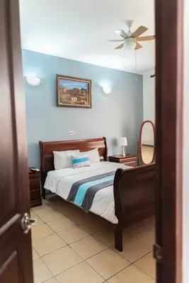 a bedroom with a bed and a ceiling fan at Hotel y Restaurante El Guarco in Cartago