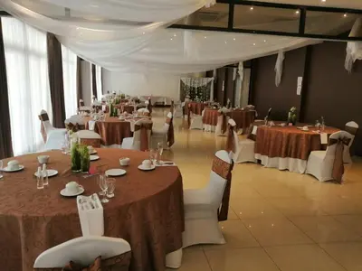 a banquet hall with tables and white chairs and tablesearcher at Hotel y Restaurante El Guarco in Cartago