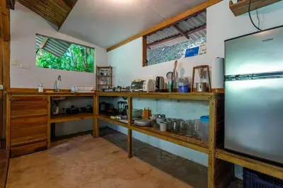 a kitchen with wooden shelves and a refrigerator at Private jungle “Loft del Rio” river access in Uvita
