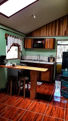 a kitchen with a wooden table and a sink at Granja los Campesinos in Monteverde Costa Rica