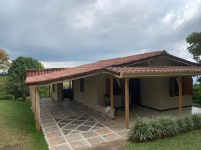 a small house with a roof with a patio at La Cabaña Poas in Poás