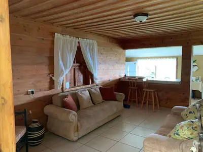 a living room with a couch and a kitchen at La Cabaña Poas in Poás