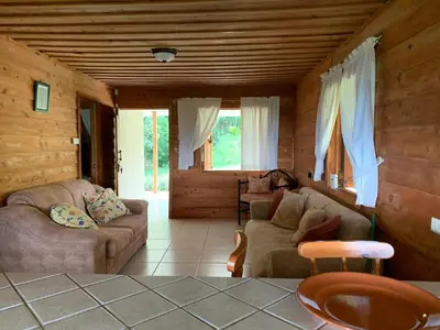 a living room with couches and chairs in a cabin at La Cabaña Poas in Poás