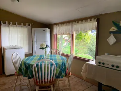 a kitchen with a table and chairs and a window at La Cabaña Poas in Poás