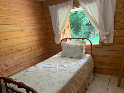 a bedroom with a bed in a log cabin at La Cabaña Poas in Poás