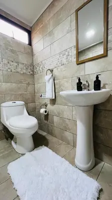 a bathroom with a white sink and a toilet at Stada San Jose Airport Hotel in Alajuela City