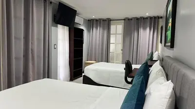 a hotel room with two beds and a couch at Stada San Jose Airport Hotel in Alajuela City
