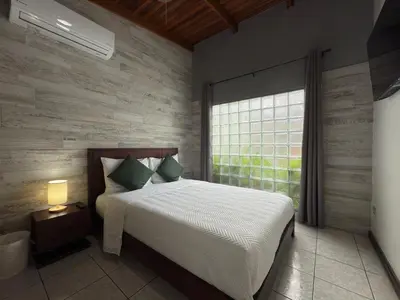 a bedroom with a large bed and a window at Stada San Jose Airport Hotel in Alajuela City