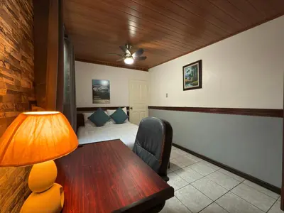 a room with a table and a bed and a lamp at Stada San Jose Airport Hotel in Alajuela City