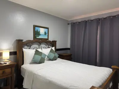 a bedroom with a bed with white sheets and pillows at Stada San Jose Airport Hotel in Alajuela City