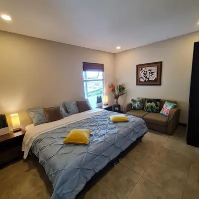 a bedroom with a large bed and a couch at Cozy private Apartment, Mirador Escazú -Great view- in Escazu