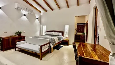 a bedroom with a bed and a wooden table at Villas Paraiso Azul in Santa Teresa Beach