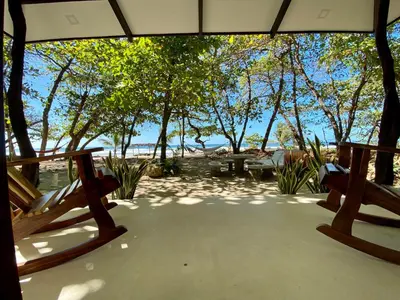 a porch with two benches and a view of the water at Villas Paraiso Azul in Santa Teresa Beach