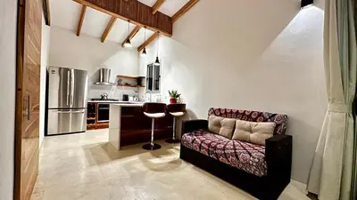 a living room with a couch and a kitchen at Villas Paraiso Azul in Santa Teresa Beach