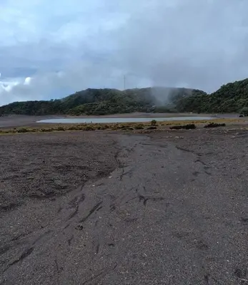 a dirt field with a body of water in the background at Casa Chicua in Sabanilla