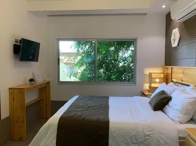 a bedroom with a large bed and a window at ARANJUEZ LOFTS Santa Ana in Santa Ana