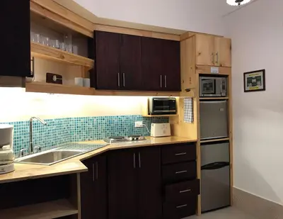a kitchen with wooden cabinets and a sink at ARANJUEZ LOFTS Santa Ana in Santa Ana