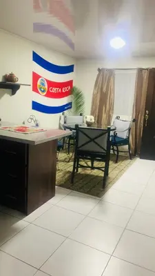 a room with a table and chairs and a flag at Around Juan Santa María in Alajuela City
