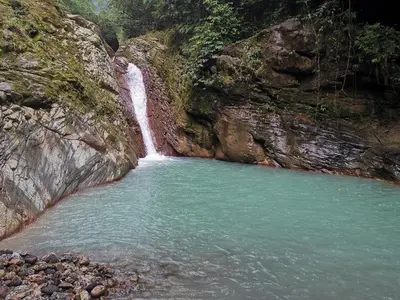a waterfall on the side of a mountain next to a river at Tiny House Dreamcatcher in Sarchí Sur