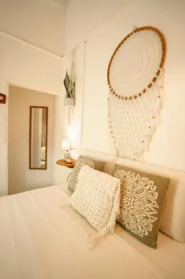 a white bedroom with a bed and a mirror on the wall at Tribe Boutique Hotel - Adults Only in Dominical