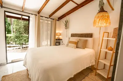 a bedroom with a bed and a large window at Tribe Boutique Hotel - Adults Only in Dominical