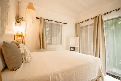 a bedroom with a white bed and a window at Tribe Boutique Hotel - Adults Only in Dominical