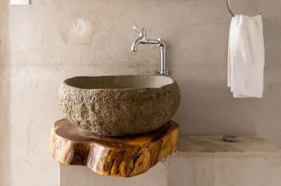 a bathroom with a stone sink on top of a wooden stump at Tribe Boutique Hotel - Adults Only in Dominical