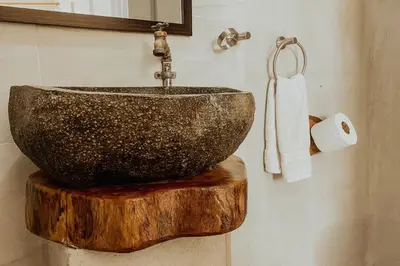 a bathroom with a bowl sink on top of a wooden stump at Tribe Boutique Hotel - Adults Only in Dominical