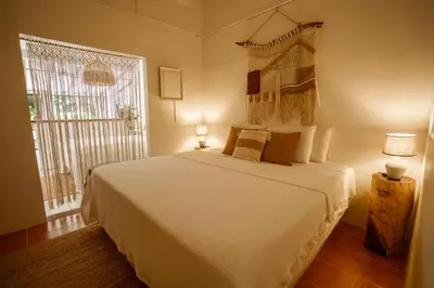 a bedroom with a large white bed and a window at Tribe Boutique Hotel - Adults Only in Dominical