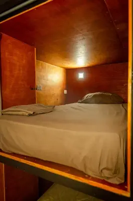 a bunk bed in a wooden room with at Akih Pods Hostel in Santa Teresa Beach