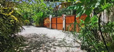 a wooden fence with a gate in a garden at Lapislazuli House & Flats with shared Pool in Santa Teresa Beach