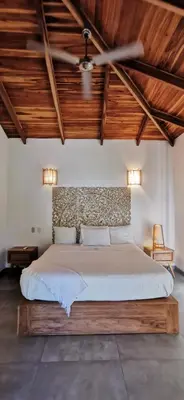 a bedroom with a large bed with wooden ceilings at Lapislazuli House & Flats with shared Pool in Santa Teresa Beach