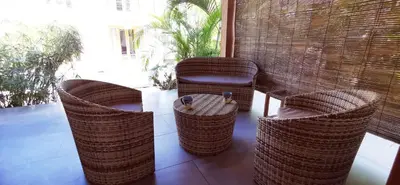 a group of wicker chairs and a table on a porch at Lapislazuli House & Flats with shared Pool in Santa Teresa Beach