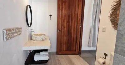 a bathroom with a sink and a wooden door at Lapislazuli House & Flats with shared Pool in Santa Teresa Beach