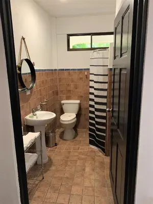 a bathroom with a toilet and a sink at La Sirena Playa Jacó in Jacó