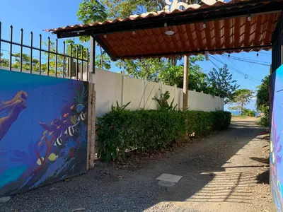 a fence with a mural on the side of a road at La Sirena Playa Jacó in Jacó