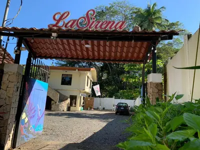 a entrance to a building with a sign on it at La Sirena Playa Jacó in Jacó