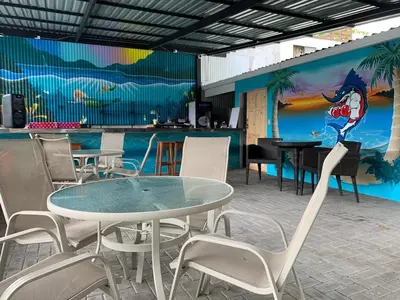a table and chairs in a restaurant with a mural at La Sirena Playa Jacó in Jacó