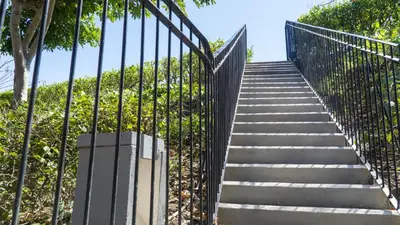 a stairway leading up to a gate with trees at Bright 2BR Condo with Partial Ocean View - Bougainvillea - Reserva Conchal in Playa Conchal