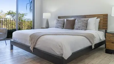 a bedroom with a large bed and a balcony at Bright 2BR Condo with Partial Ocean View - Bougainvillea - Reserva Conchal in Playa Conchal