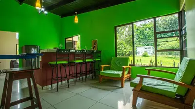 a green room with a bar with green chairs at Green Leaf House in Fortuna