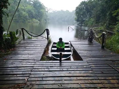 a person sitting on a boat on a dock at El Zota Hotel in Cariari