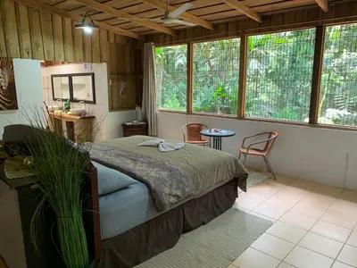a bedroom with a bed in a room with windows at El Zota Hotel in Cariari