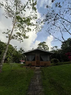 a small house with a door in a field at El Zota Hotel in Cariari