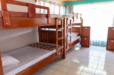 a room with three bunk beds in a hostel at Hostel Bouganvilia Bed and Breakfast in San Ramón