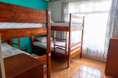 a room with two bunk beds and a window at Hostel Bouganvilia Bed and Breakfast in San Ramón