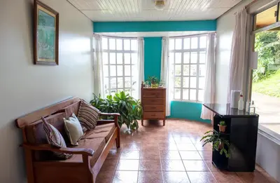 a living room with a couch and some windows at Hostel Bouganvilia Bed and Breakfast in San Ramón